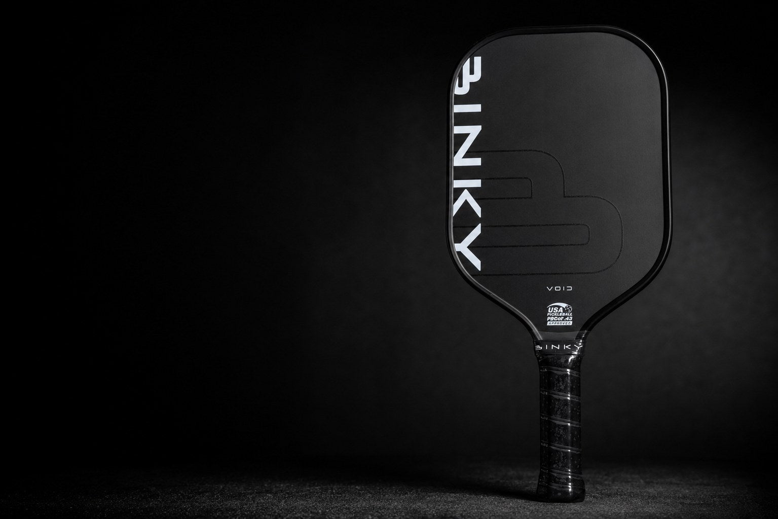BINKY VOID paddle standing upright on a black surface